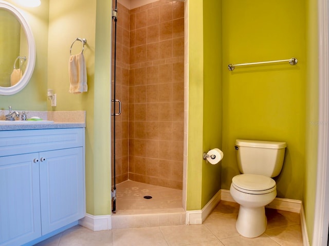 bathroom featuring tile patterned floors, toilet, a shower with shower door, and vanity