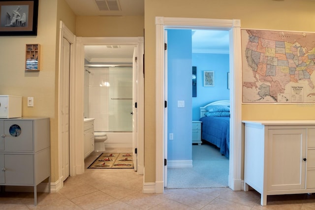 hallway with light tile patterned floors and crown molding