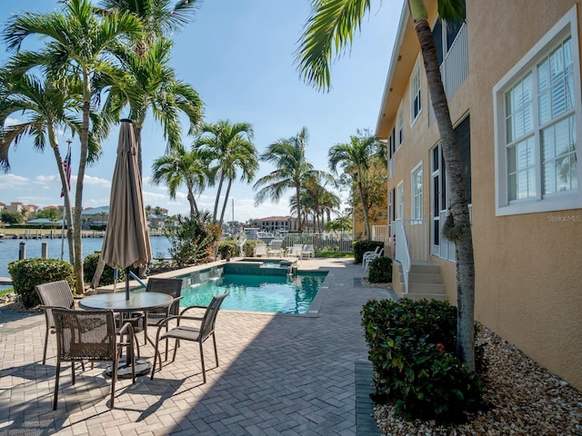 view of swimming pool with a patio area and a water view