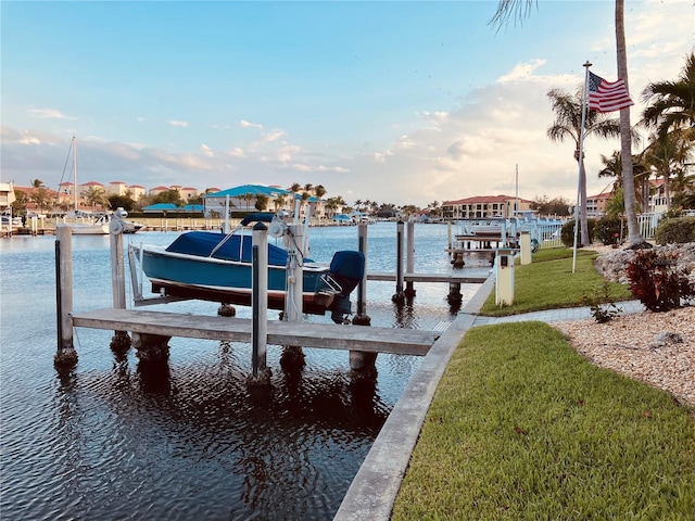 view of dock with a water view and a yard