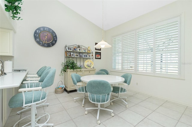 dining space featuring lofted ceiling and light tile patterned floors