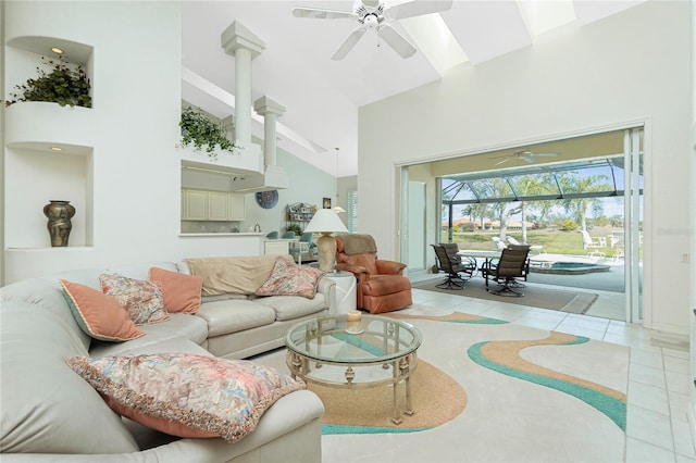 tiled living room with ceiling fan and high vaulted ceiling