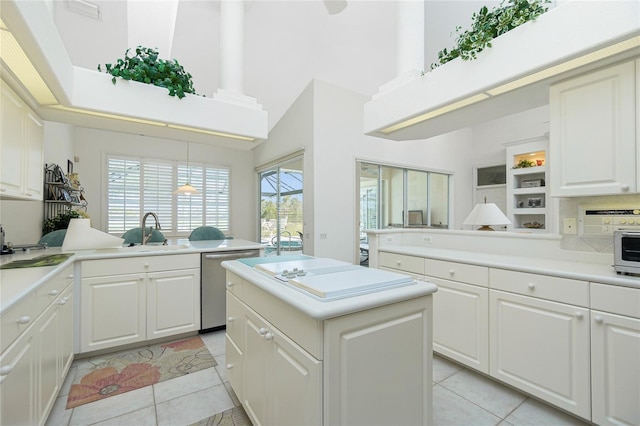 kitchen with a kitchen island, white cabinetry, dishwasher, sink, and light tile patterned floors