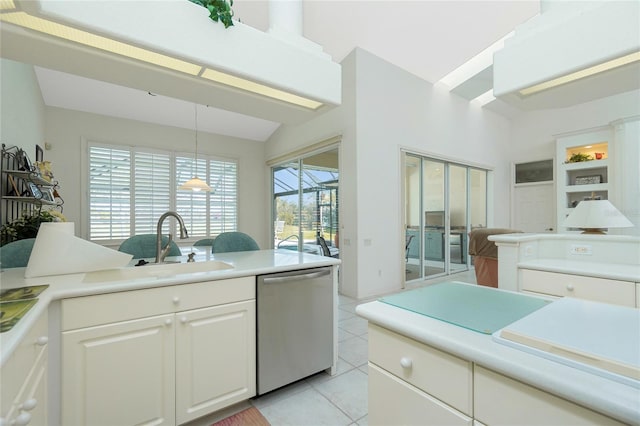 kitchen with sink, white cabinetry, decorative light fixtures, light tile patterned floors, and stainless steel dishwasher