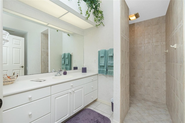 bathroom featuring vanity, tile patterned floors, and a tile shower