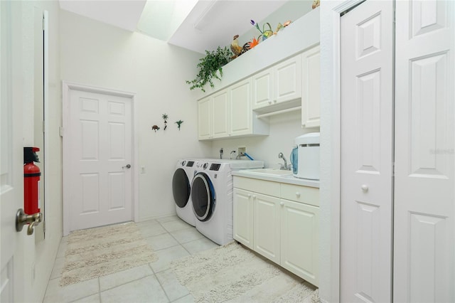 laundry area featuring cabinets, light tile patterned flooring, separate washer and dryer, and sink