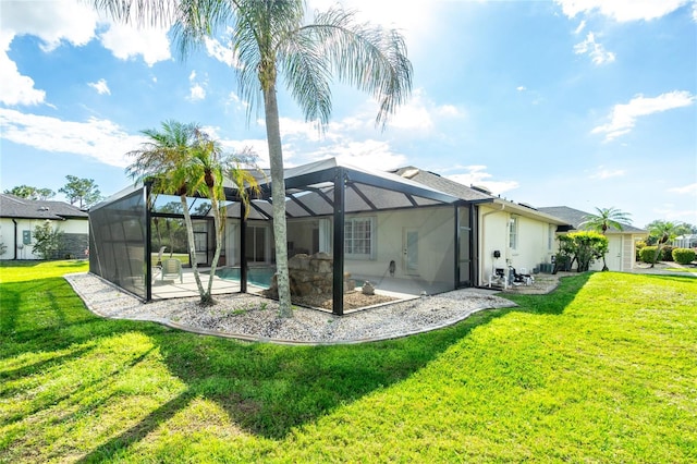 rear view of house with a lanai, a yard, and a patio area