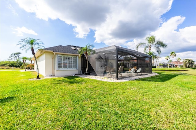 rear view of property featuring a patio, a lanai, and a lawn