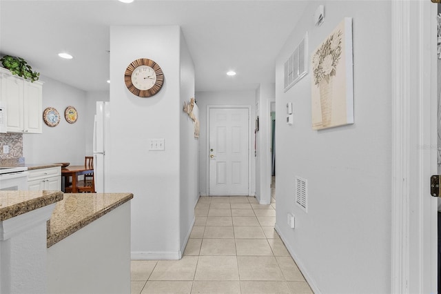 corridor featuring light tile patterned floors, visible vents, recessed lighting, and baseboards