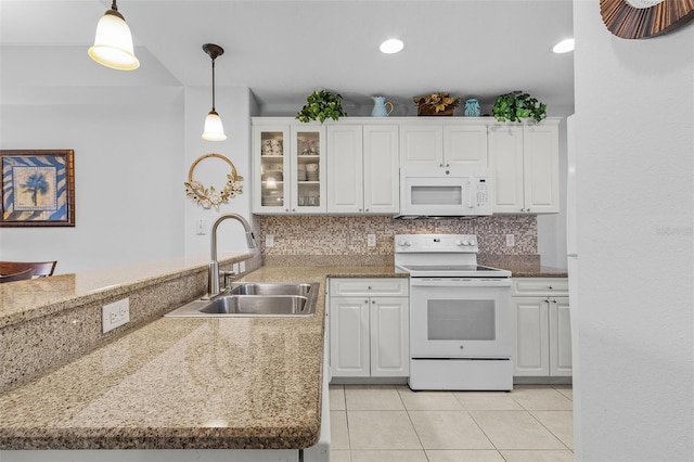 kitchen featuring decorative backsplash, white appliances, a peninsula, and a sink