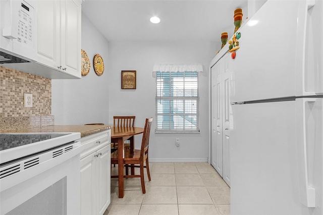 kitchen with white cabinetry, white appliances, light tile patterned floors, and tasteful backsplash