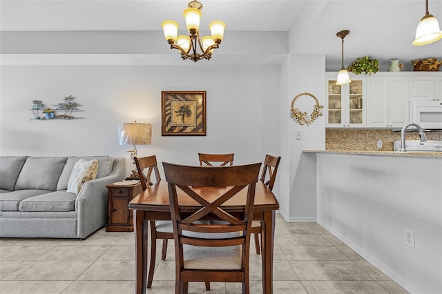 dining room with a notable chandelier, baseboards, and light tile patterned floors