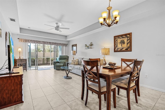 dining area with light tile patterned floors, visible vents, baseboards, a tray ceiling, and ceiling fan with notable chandelier