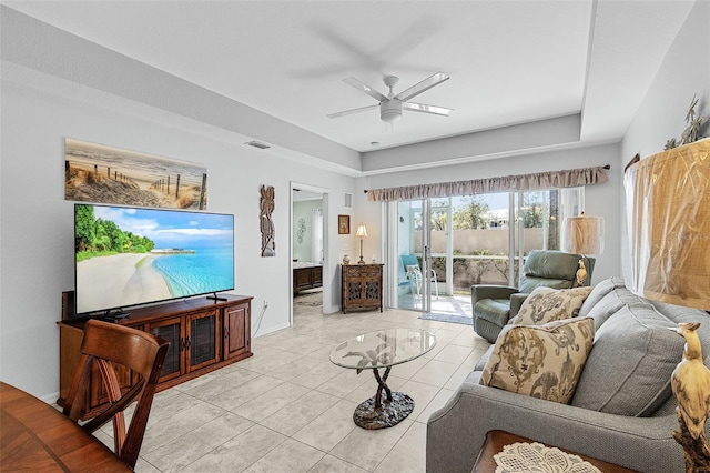 living area with light tile patterned floors, visible vents, baseboards, and a ceiling fan