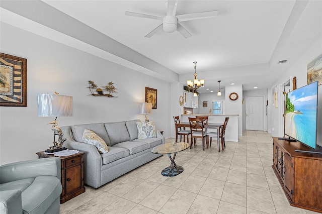 living room with light tile patterned floors, ceiling fan with notable chandelier, visible vents, and baseboards