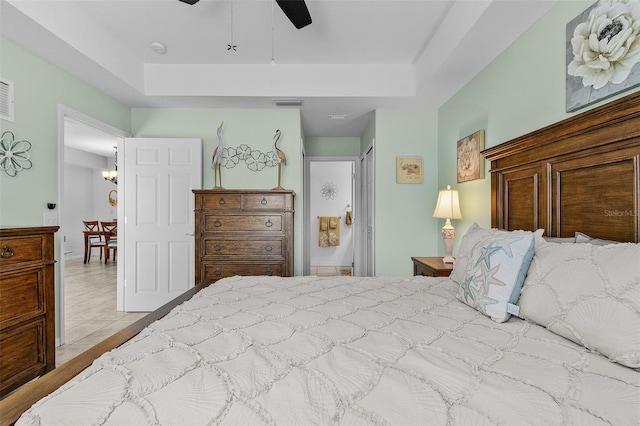 bedroom with visible vents, a raised ceiling, and ceiling fan