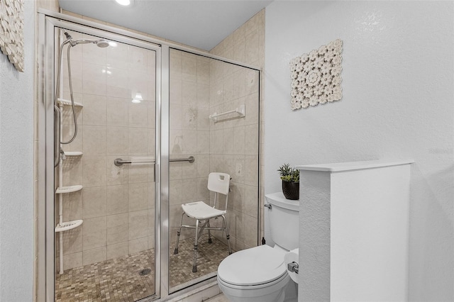 bathroom featuring toilet and a shower stall