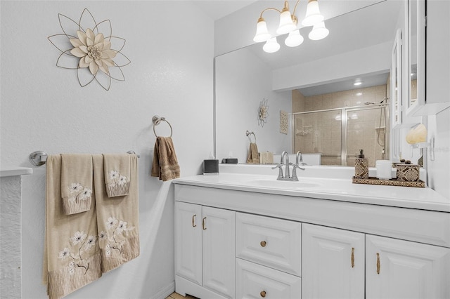 bathroom featuring vanity, a shower stall, and a chandelier