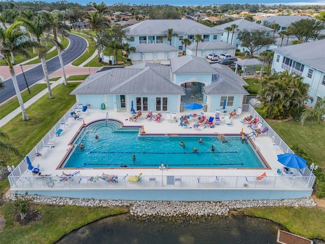 back of house featuring a community pool, a water view, a patio, and fence