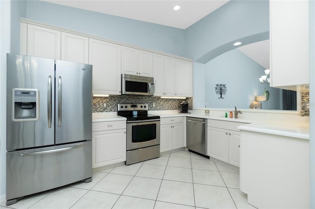 kitchen featuring stainless steel appliances, white cabinets, decorative backsplash, light tile patterned floors, and sink