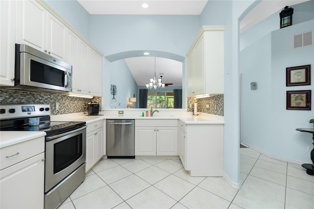 kitchen featuring stainless steel appliances, sink, light tile patterned floors, white cabinets, and pendant lighting