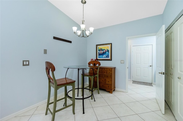 dining area featuring a notable chandelier, light tile patterned floors, and vaulted ceiling