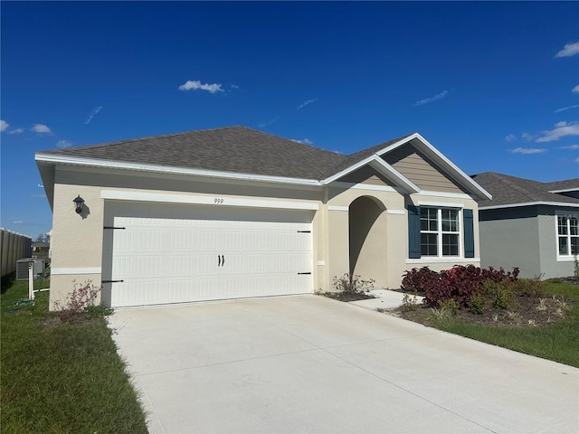 ranch-style house with a shingled roof, driveway, an attached garage, and stucco siding