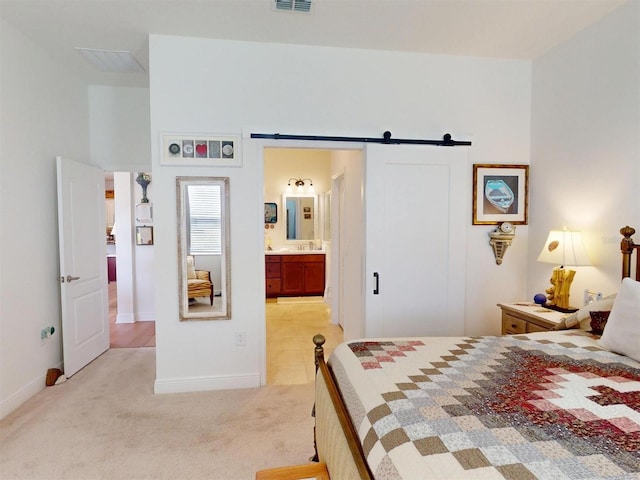24313 Westgate Blvd, Punta Gorda, FL 33980 - bedroom featuring light carpet, baseboards, a barn door, and ensuite bath