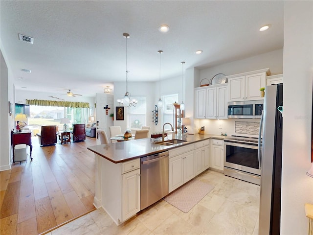 24313 Westgate Blvd, Punta Gorda, FL 33980 - kitchen featuring appliances with stainless steel finishes, a sink, open floor plan, a peninsula, and ceiling fan