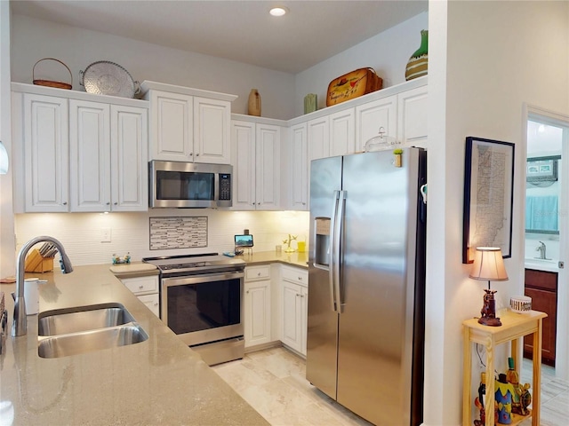 24313 Westgate Blvd, Punta Gorda, FL 33980 - kitchen with appliances with stainless steel finishes, a sink, and white cabinets