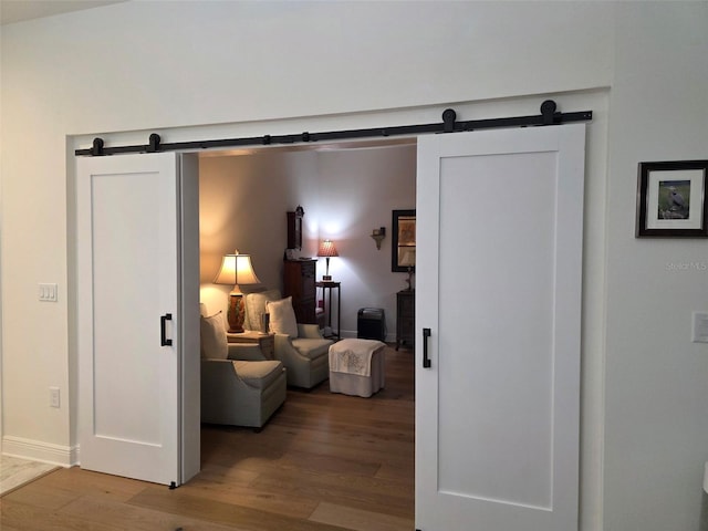 24313 Westgate Blvd, Punta Gorda, FL 33980 - corridor featuring a barn door and wood finished floors