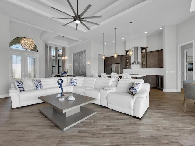 living room featuring a high ceiling, dark wood-type flooring, a chandelier, and french doors