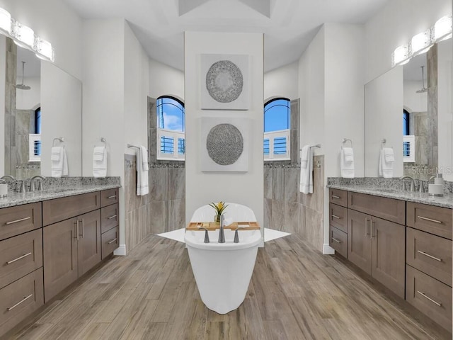 bathroom featuring a shower, hardwood / wood-style floors, and vanity