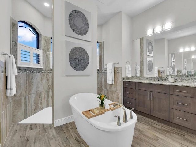 bathroom featuring vanity, wood-type flooring, and plus walk in shower