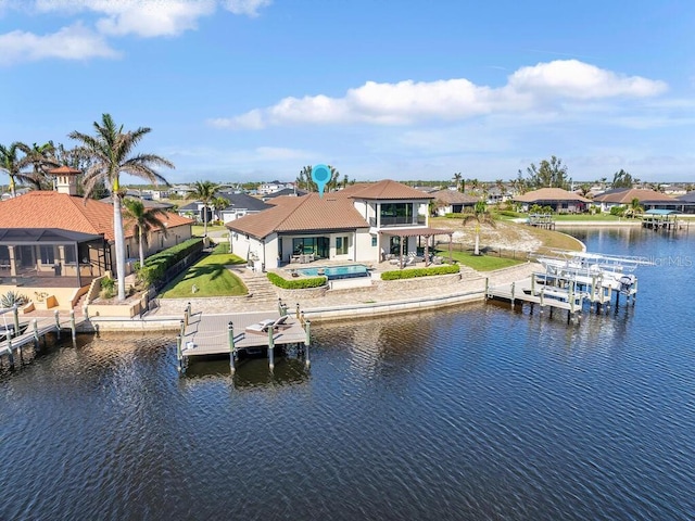 dock area featuring a swimming pool with hot tub, a patio area, and a water view