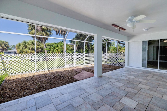 unfurnished sunroom featuring a ceiling fan