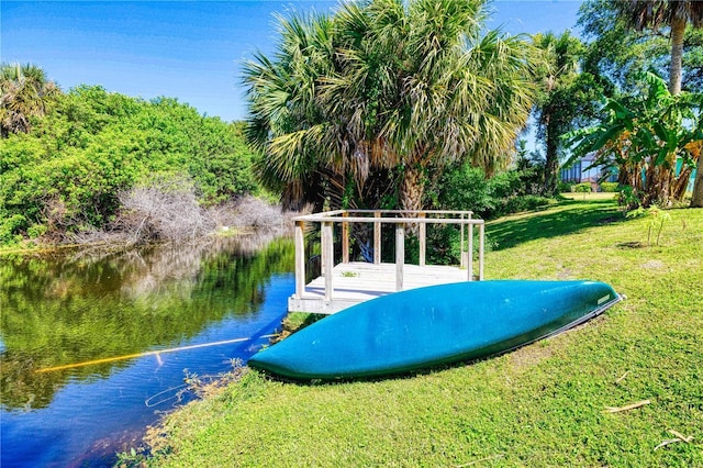 view of property's community with a lawn and a water view