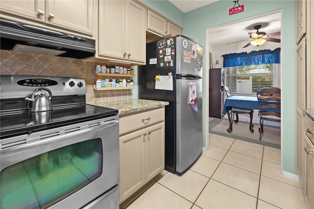 kitchen with light tile patterned flooring, backsplash, exhaust hood, stainless steel appliances, and cream cabinetry