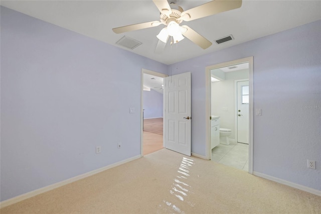 unfurnished bedroom featuring light colored carpet, connected bathroom, visible vents, and baseboards