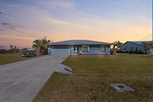 single story home with a garage and a lawn