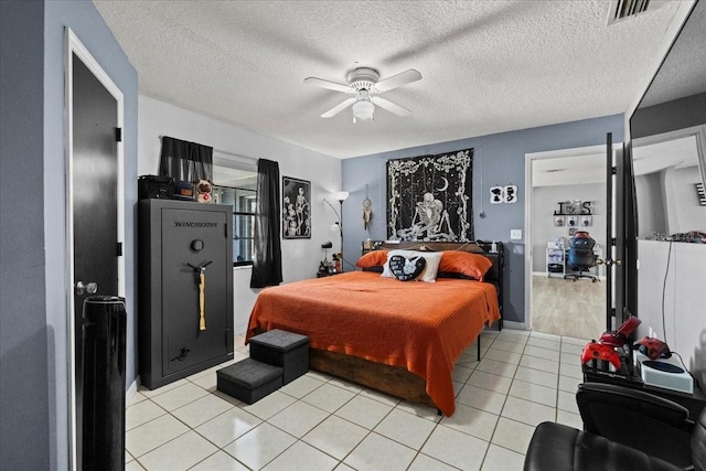 tiled bedroom featuring a textured ceiling and ceiling fan