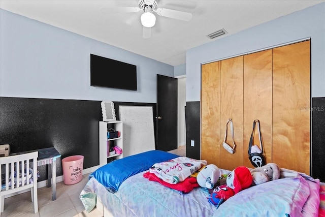 bedroom featuring ceiling fan, a closet, and light tile patterned floors