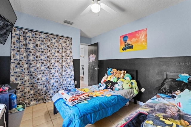 bedroom with light tile patterned floors, a textured ceiling, and ceiling fan