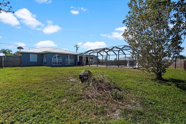 view of yard featuring an outdoor fire pit and glass enclosure