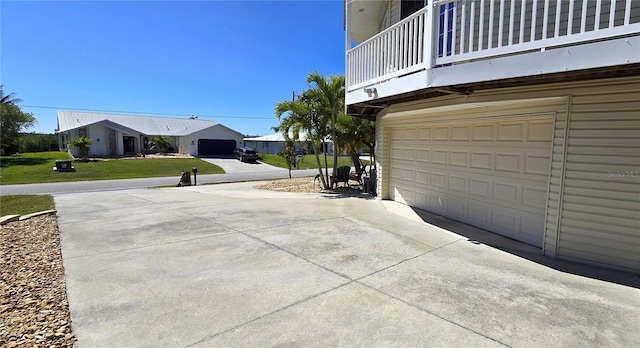 exterior space featuring driveway, a lawn, and an attached garage