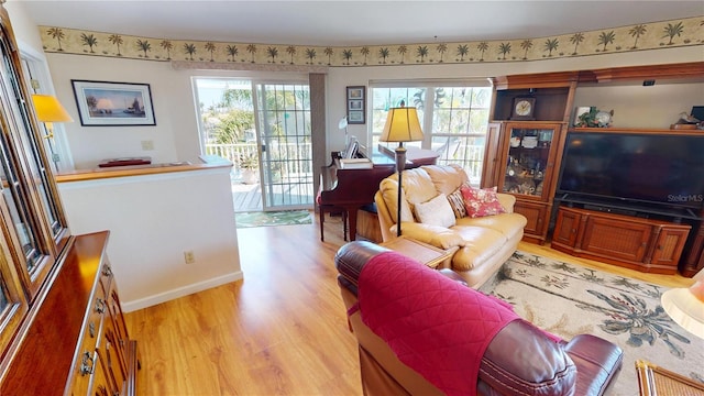 living area featuring light wood-style floors and baseboards