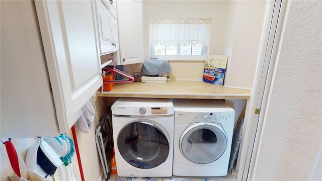 washroom featuring cabinet space and separate washer and dryer