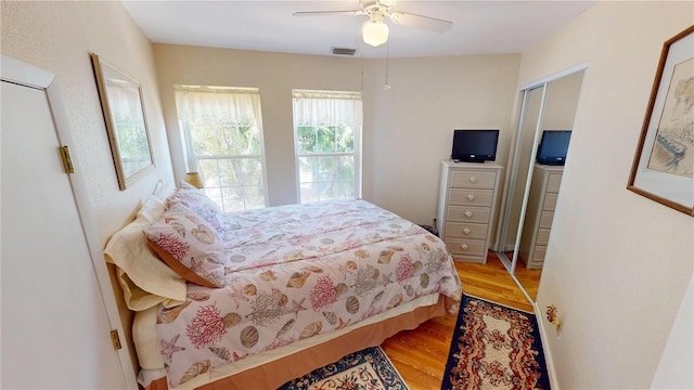 bedroom featuring ceiling fan, visible vents, and wood finished floors