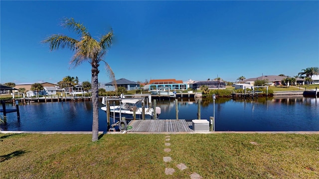 dock area with a water view, a residential view, and a lawn