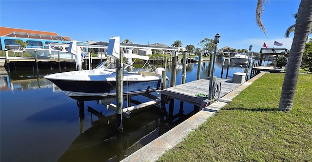 view of dock with a water view, boat lift, and a lawn